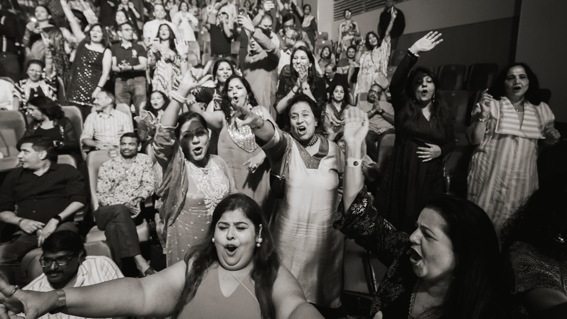 Black and white frame of the audience on their feet, singing along at The Jugni Concert