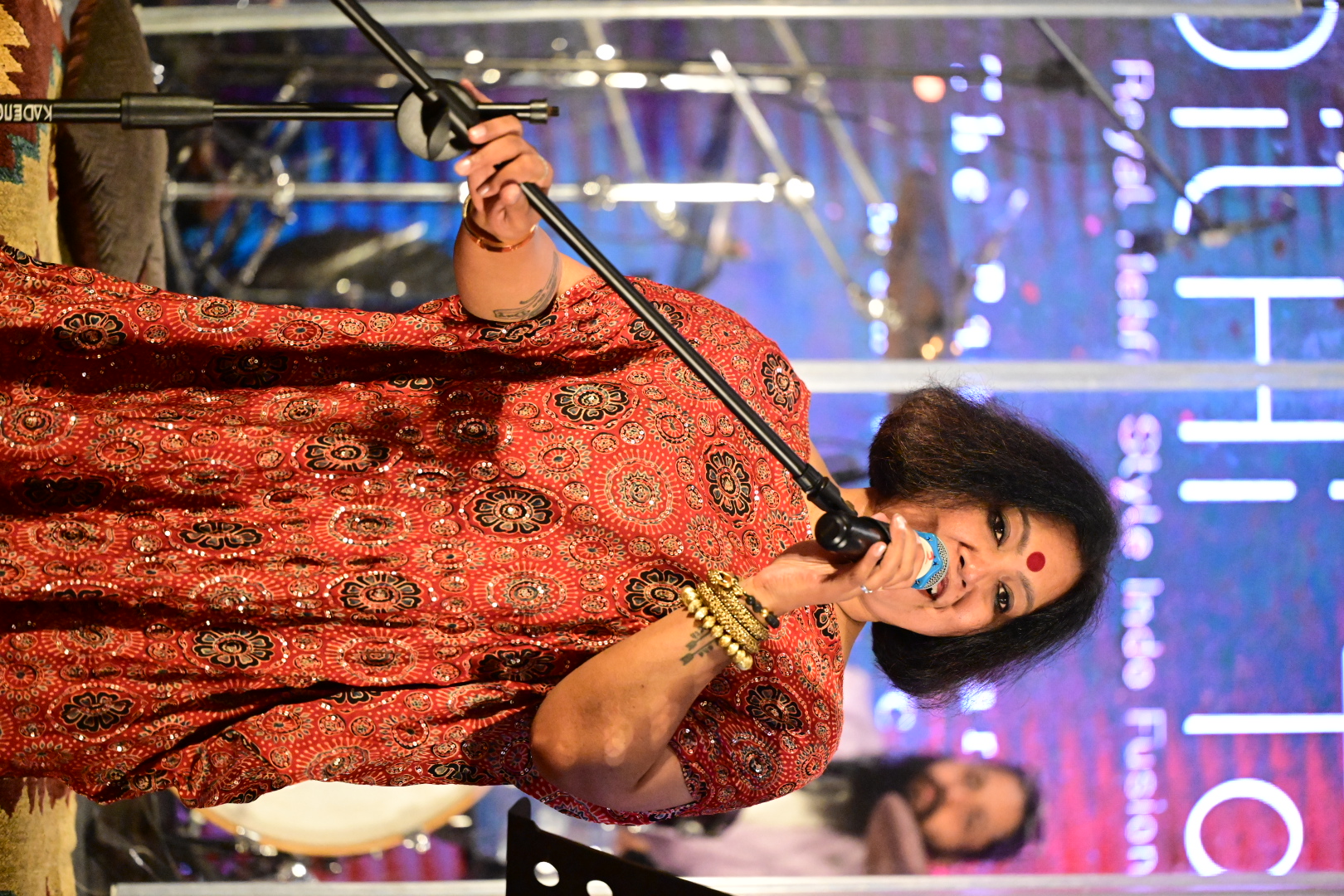 Paapori Harsh singing at the mic in front of the Dil Hi To Hai backdrop